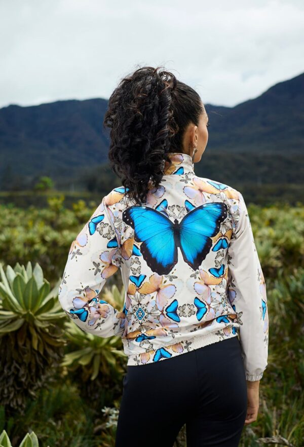 Chaqueta beige y mariposa azul